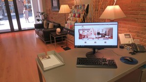 A reception desk with a computer monitor displaying a real estate website, a telephone, and a keyboard. - Studio apartment Barcelona with terrace (Barcelone)