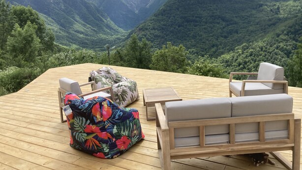 A wooden deck with outdoor furniture, including a sofa and chairs, overlooking a mountainous landscape with lush greenery. - Modern and comfortable chalet with stunning views of the Ariege Pyrenees (Gestiès)