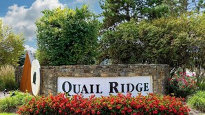 A sign for Quail Ridge with a stone wall and red flowers in front. - Team or Family Stay/Peloton/1.9 mile to Grand Park (Westfield)