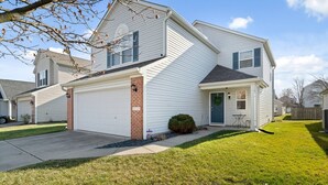 A two-story house with a garage, a front porch, and a small front yard. - Team or Family Stay/Peloton/1.9 mile to Grand Park (Westfield)