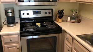 A kitchen with a stainless steel stove, oven, and microwave. There is a coffee maker on the counter. - AUGUST REDUCED/SEPTEMBER AVAILABLE!! (Orange Beach)