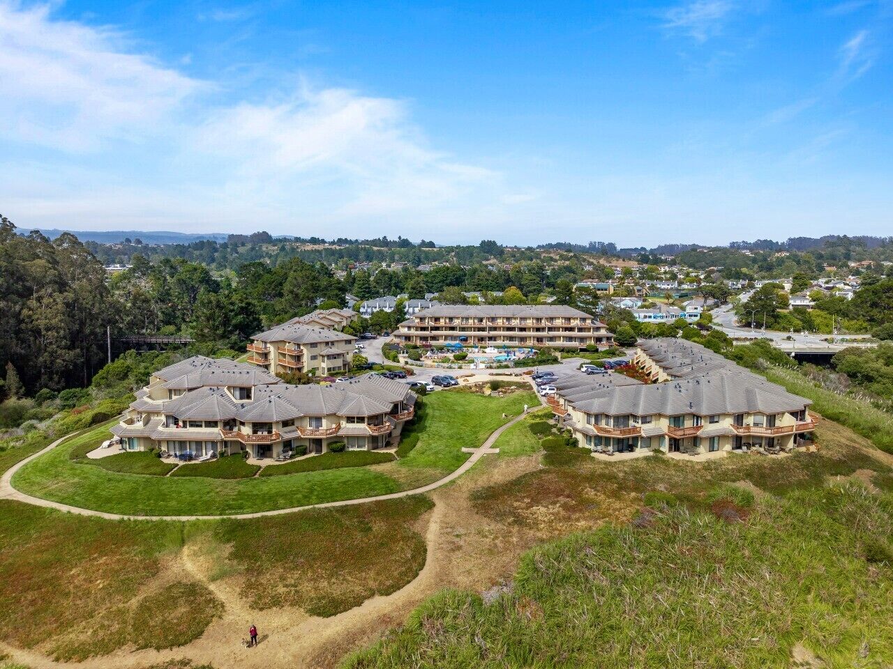 A residential complex with multiple two-story buildings, each featuring balconies and a central courtyard.