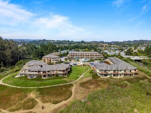 A residential complex with multiple two-story buildings, each featuring balconies and a central courtyard.