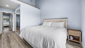 Un dormitorio con una cama grande, cabecera de madera y una mesita de noche con una cesta de mimbre.
