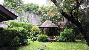 Um jardim com um caminho de pedra que leva a um gazebo.