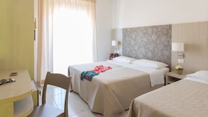Una habitación de hotel con dos camas, un escritorio y una silla.