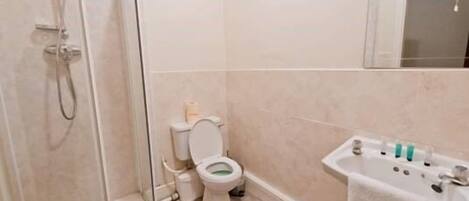 A bathroom with a shower, toilet, and sink.