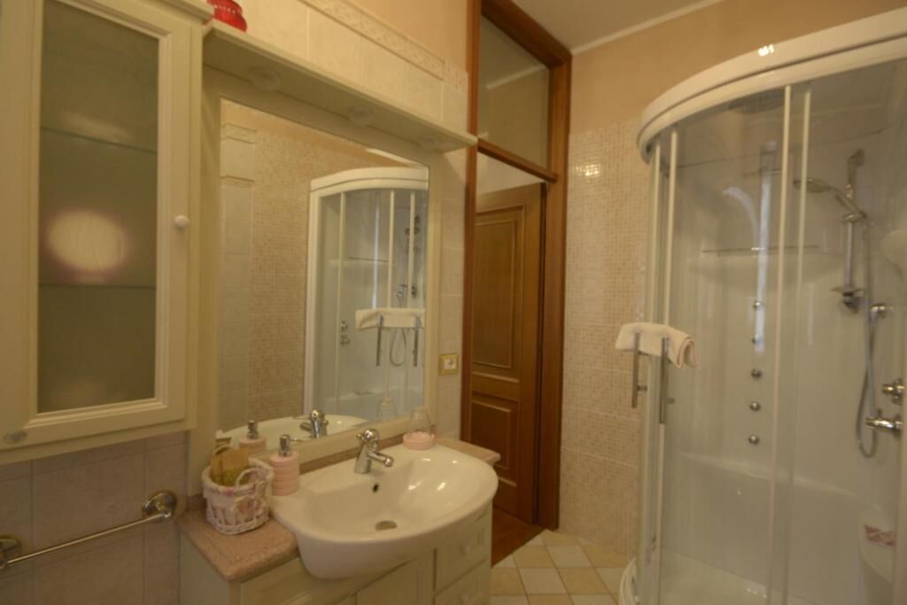 Un bagno con lavandino, specchio e doccia.