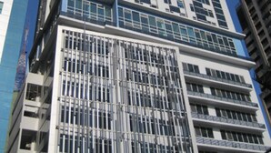 A tall, modern high-rise building with a grid of windows and balconies. - Premium Residence The Currency Ortigas (Pasig)