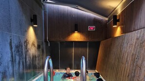 An indoor swimming pool with wooden walls and a tiled floor. - Louis Boutique Hotel (Changwon)