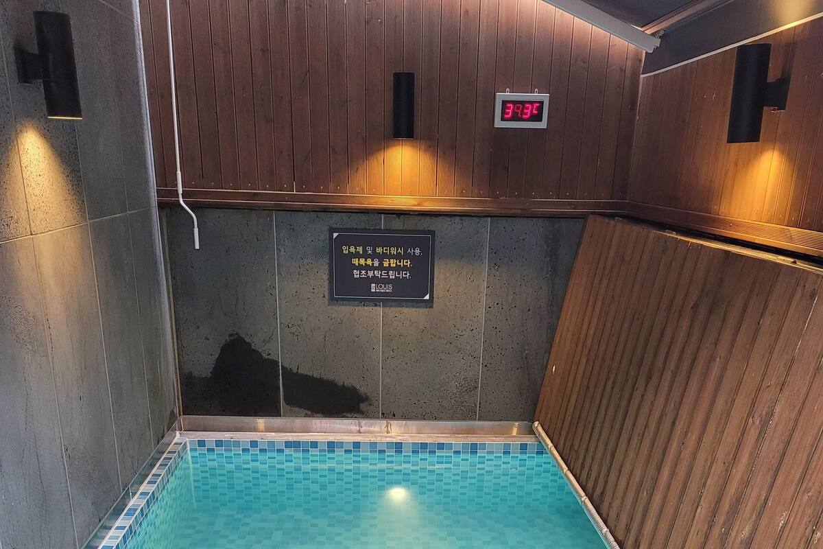 A swimming pool with a tiled floor and metal handrails.