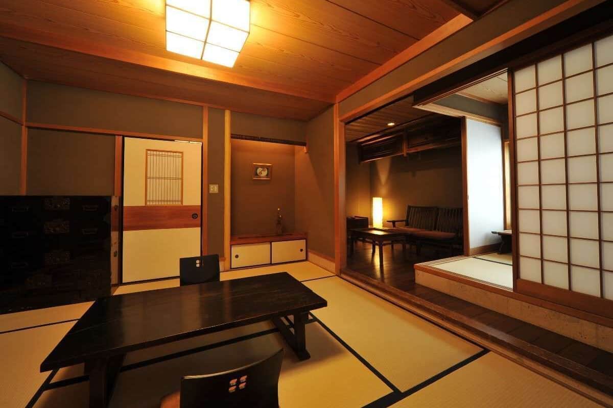 Une pièce de style japonais traditionnel, avec un sol recouvert de tatamis, une table basse et des portes coulissantes.