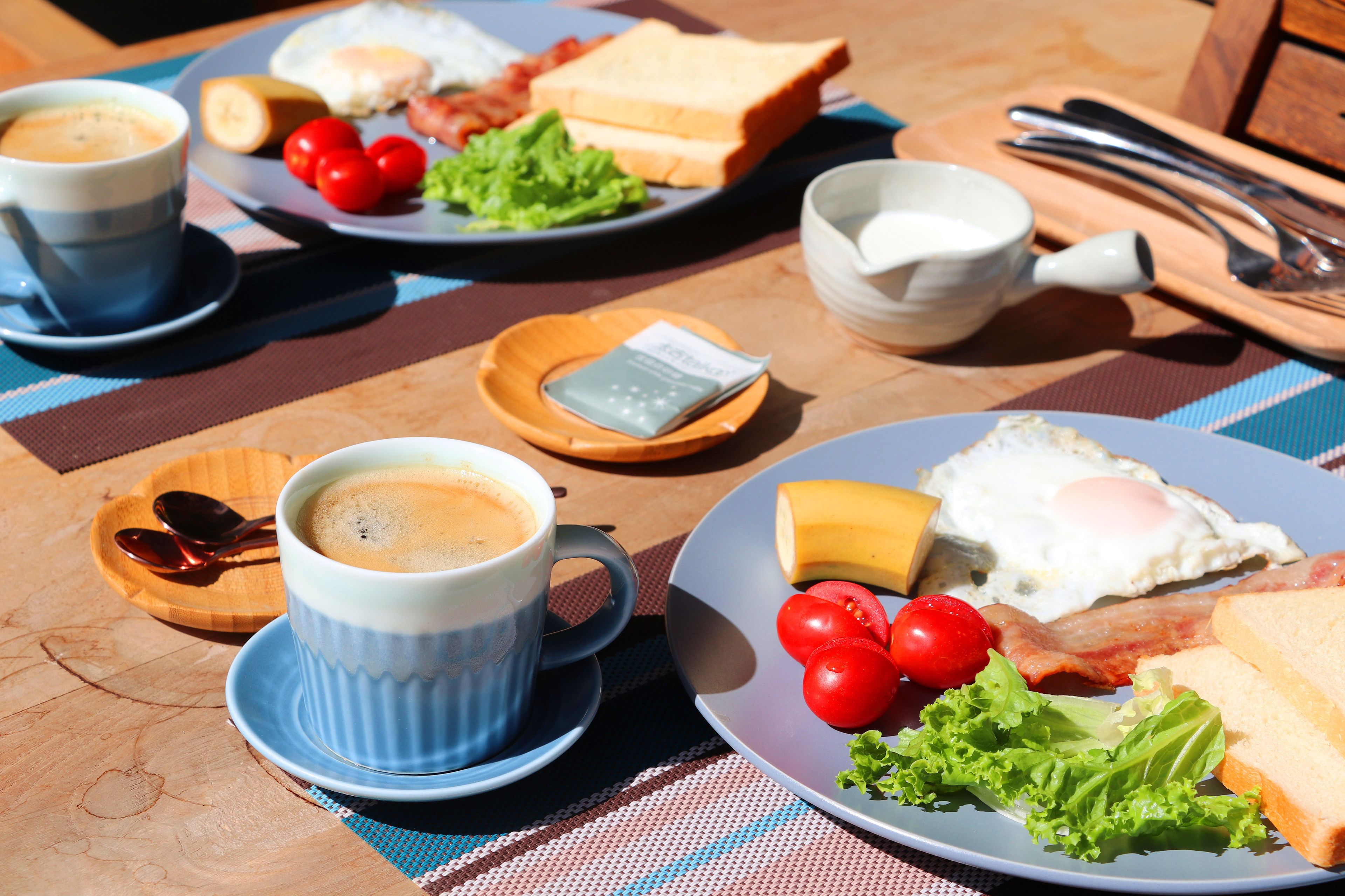 Un desayuno con tostadas, huevos, tomates y una taza de café.