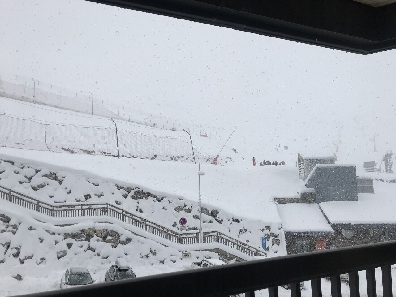 A snowy outdoor scene with a staircase and a fence.