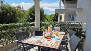 An outdoor dining area with a table set for four, surrounded by chairs. - Grand T3 60 m², pool, 2 parking, 4 bikes, Beach, Shops, Marina Port (Saint-Cyprien)