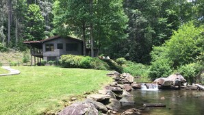 A cabin with a stone pathway leading to a small waterfall. - Private Riverfront Cabin: 9 Acres,  Trails to Waterfalls (Sapphire)