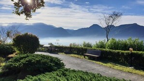 Un sendero que lleva a un banco con vista a montañas y un cuerpo de agua.