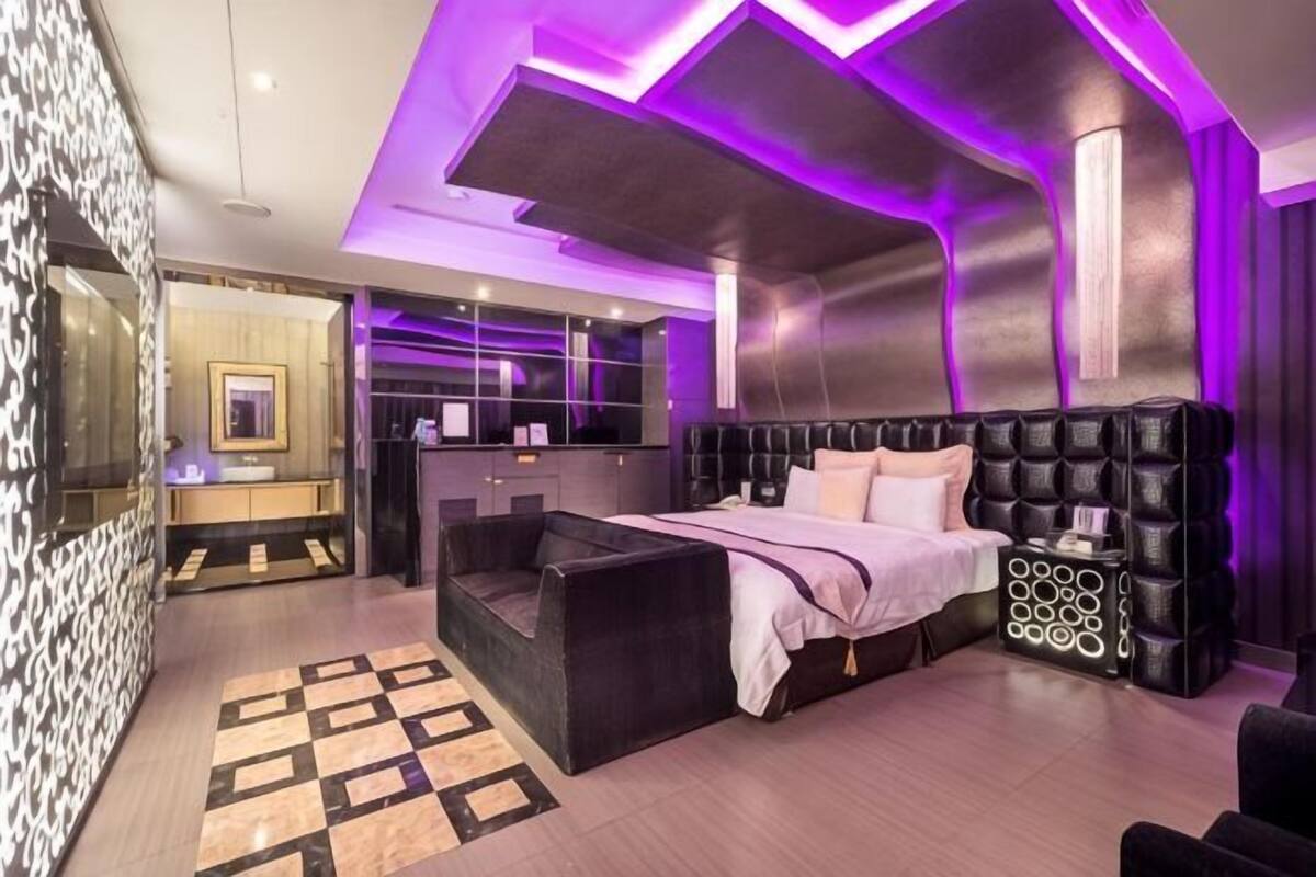 Een moderne slaapkamer met een groot bed, een zithoek en een kaptafel.
