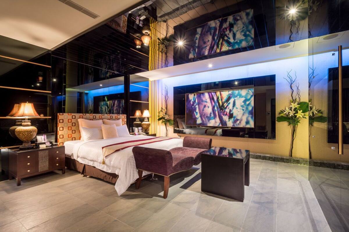 Een moderne hotelkamer met een groot bed, een flatscreen televisie, een bureau en een zithoek.