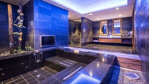 Un bany modern amb una banyera gran, un lavabo amb mirall i una zona de dutxa.