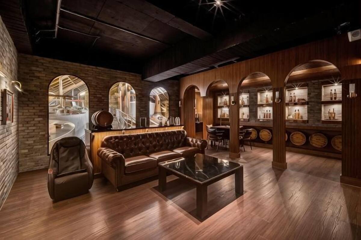 Een gezellige zithoek met lederen zitplaatsen, een bijzettafeltje en een bar met flessenkasten.