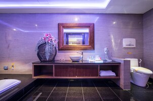 Un baño moderno con un lavamanos tipo recipiente, un espejo y un inodoro.