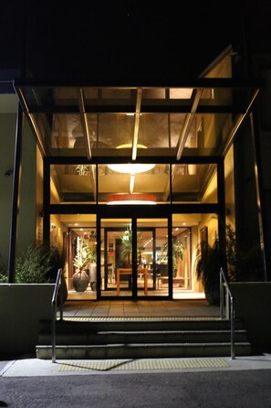 A modern building entrance with glass doors and a ramp leading up to the entrance. - The Windsor Castle Hotel (East Maitland)