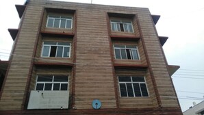 A multi-story building with a brick facade and multiple windows.