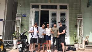 Un grupo de personas de pie frente a un edificio con un letrero que dice 'Sweet House'.