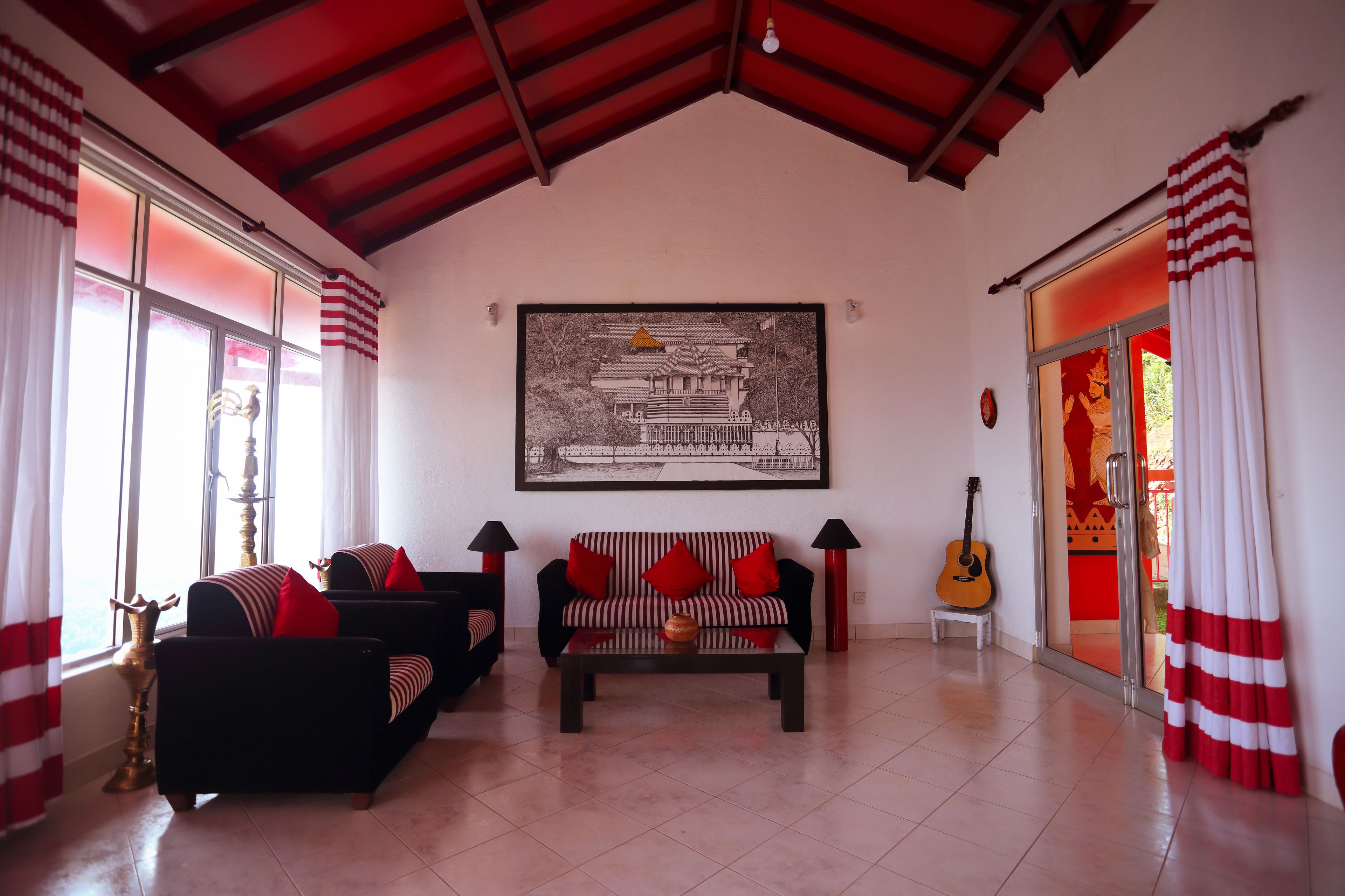 A living room with a sofa, a coffee table, and a guitar.
