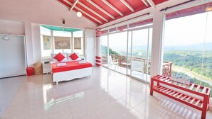A spacious bedroom with a large bed, a balcony with a view, and a red bench. - Redhill Kandy (Kandy)