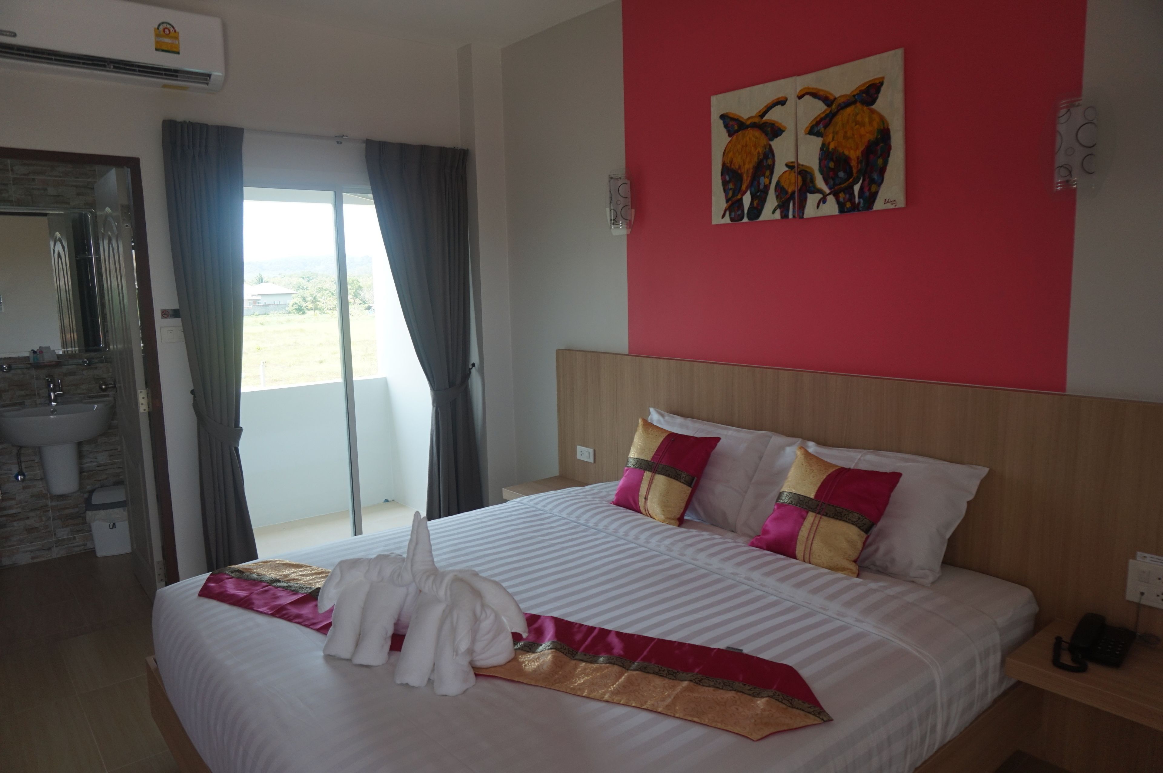 Habitación de hotel con cama, baño y balcón.