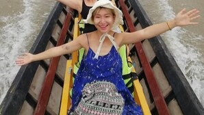 A group of people in a boat on a river.