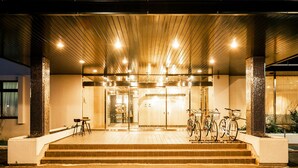 A building entrance with a covered area, steps, and bicycles parked outside. - Hotel AreaOne Tokai (Tokai-mura)