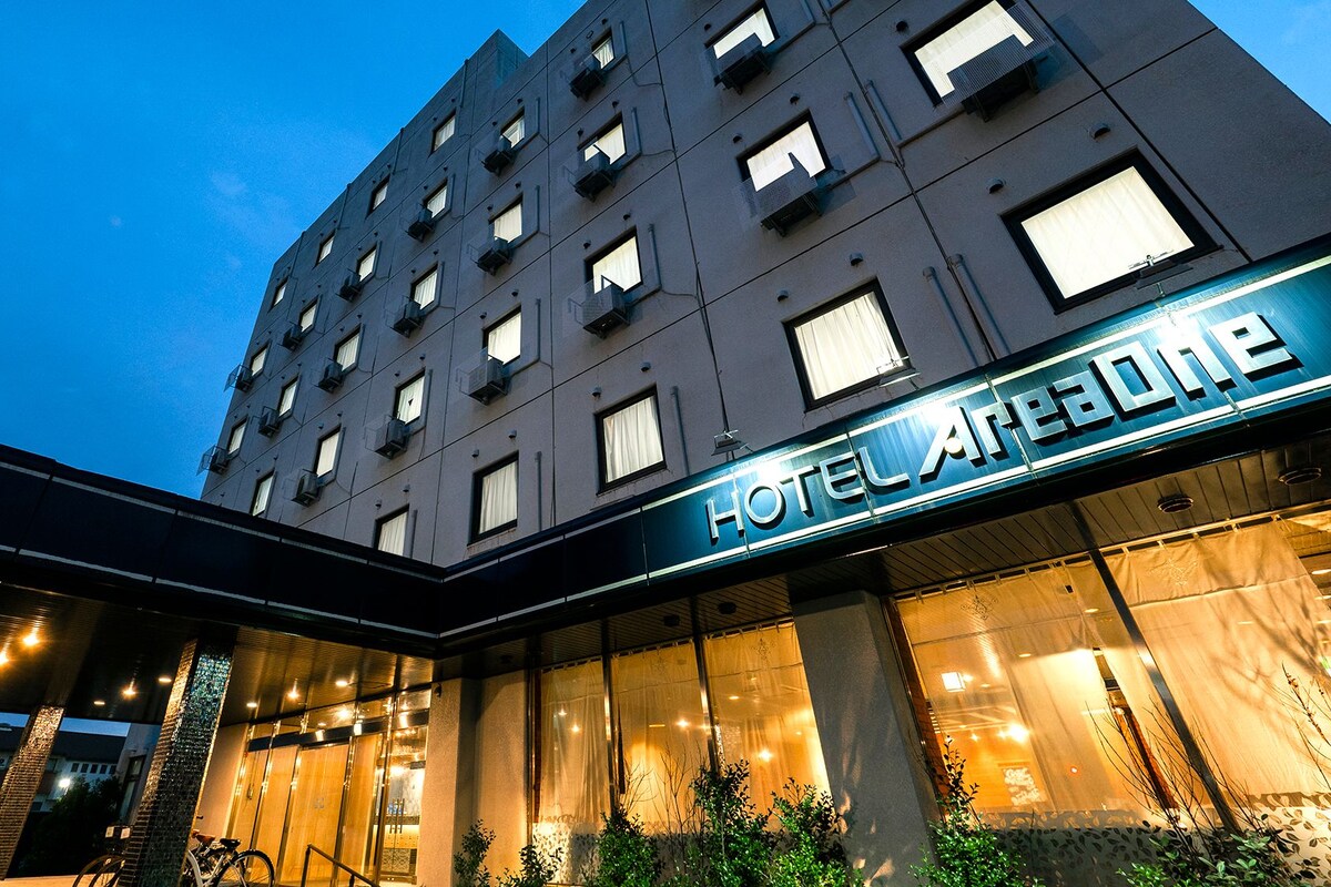 A multi-story hotel building with a prominent 'HOTEL ACADEME' sign, large windows, and a modern facade.