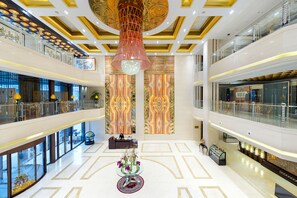 A spacious atrium with a central chandelier, a reception desk, and a seating area. - Beijing Baifuyi Apartment Dongzhimen (Beijing)