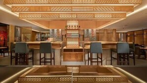A modern bar area with wooden paneling and bar stools. - Beijing Baifuyi Apartment Dongzhimen (Beijing)