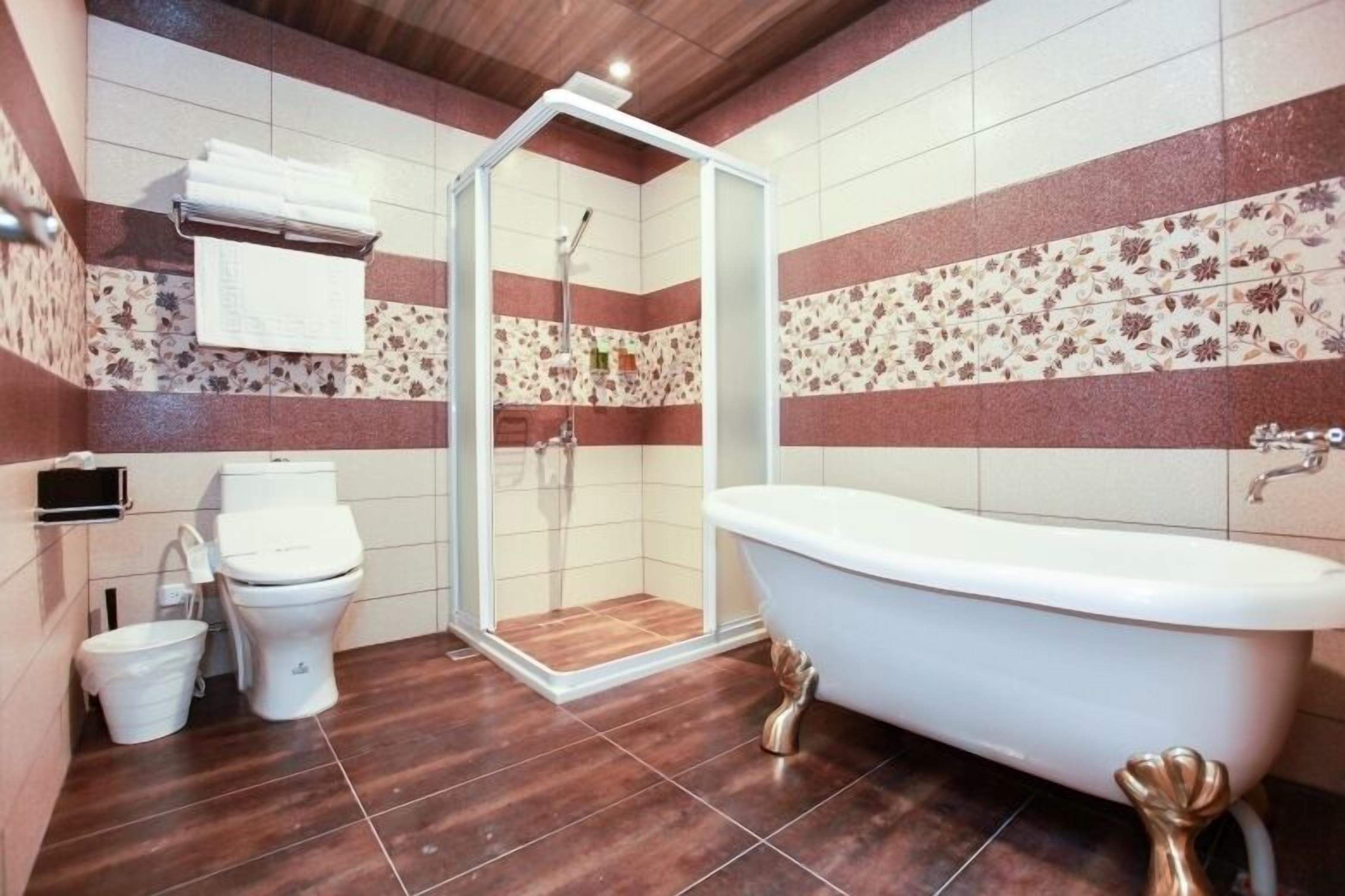 Een badkamer met een vrijstaand bad, toilet en douchecabine.