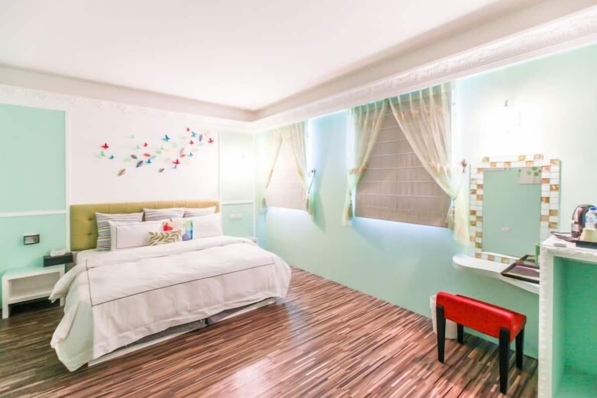 Una habitación con una cama, un pequeño banco, un lavabo y un espejo.