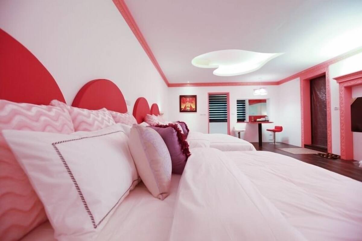 Un dormitorio moderno con una cama grande, un escritorio y una silla.