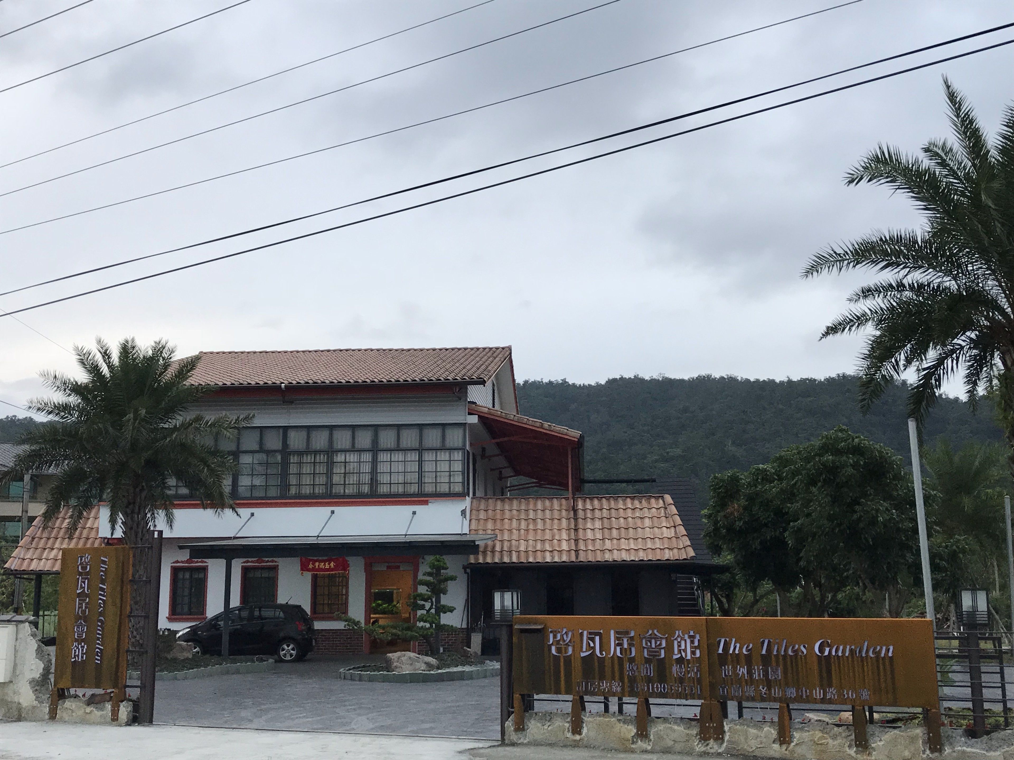 A building with a tiled roof and a sign that reads "The Tiles Garden."