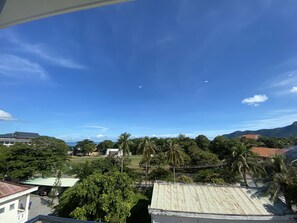 A residential area with houses, palm trees, and a clear blue sky. - Nha Khach Con Dao (Ho Chi Minh City)