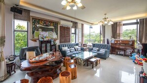 A spacious living room with a sofa set, a coffee table, and a piano. - My Sweetie B&B (Dongshan)