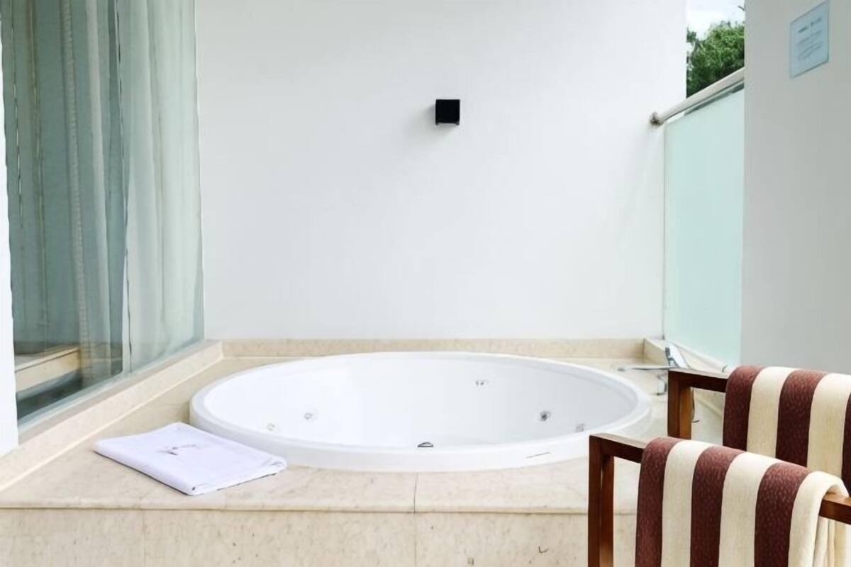 Een wellnessruimte met een jacuzzi, een handdoek en een stoel.