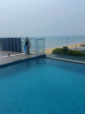A swimming pool with a view of the beach and ocean.