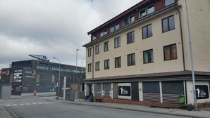 A building with multiple windows and a storefront with a sign. - Kirkenes Hotel (South Varanger)