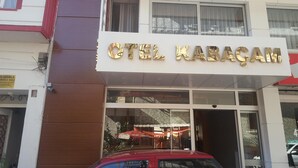 Een hotel ingang met een bord waarop 'OTEL KARAGAM' staat.