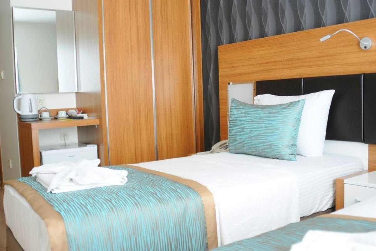 Une chambre d’hôtel avec un lit, une table de chevet et un miroir.