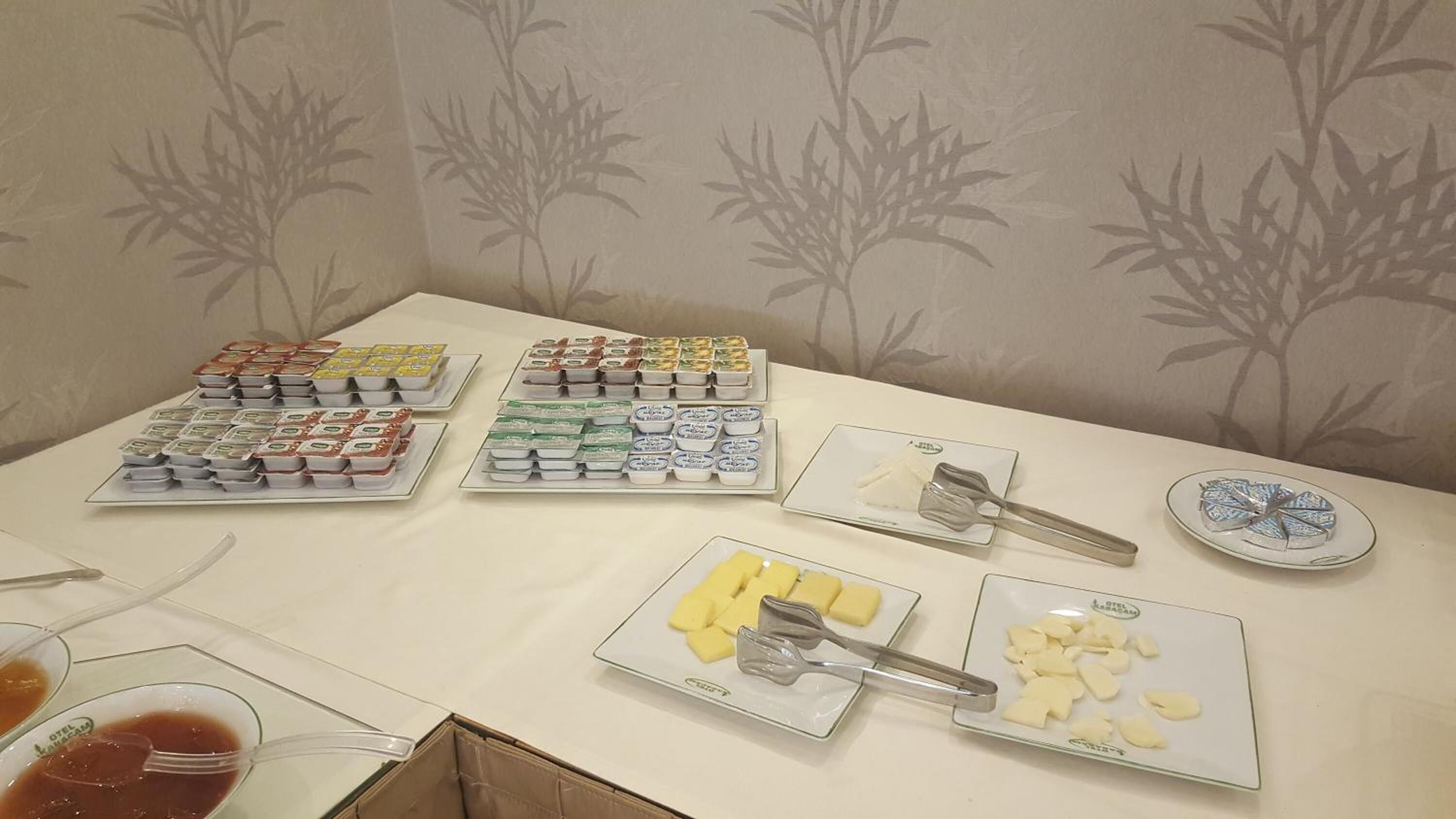 A buffet table with various food items and utensils.