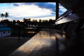 Un banco de madera con vistas a palmeras y un edificio con techo azul.